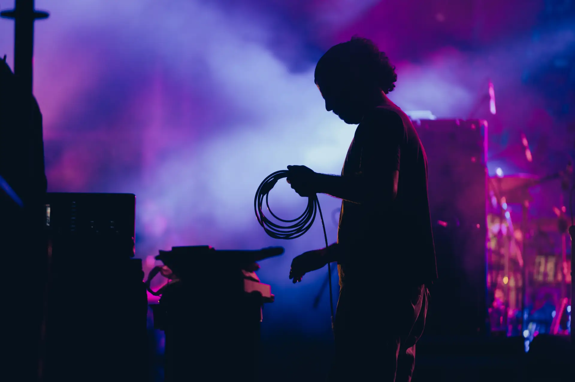 Silhouette of adult on stage with purple lighting